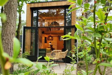 Zicht op het tiny house waar lampen branden