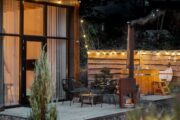 Brandende buitenkachel en hot tub op het terras van het tiny house