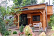 Overdekt terras met een hangstoel, bij een tiny house in Beekbergen