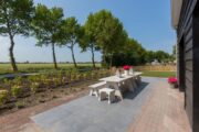 Terras met lange eettafel bij het vakantiehuis in Zeeland