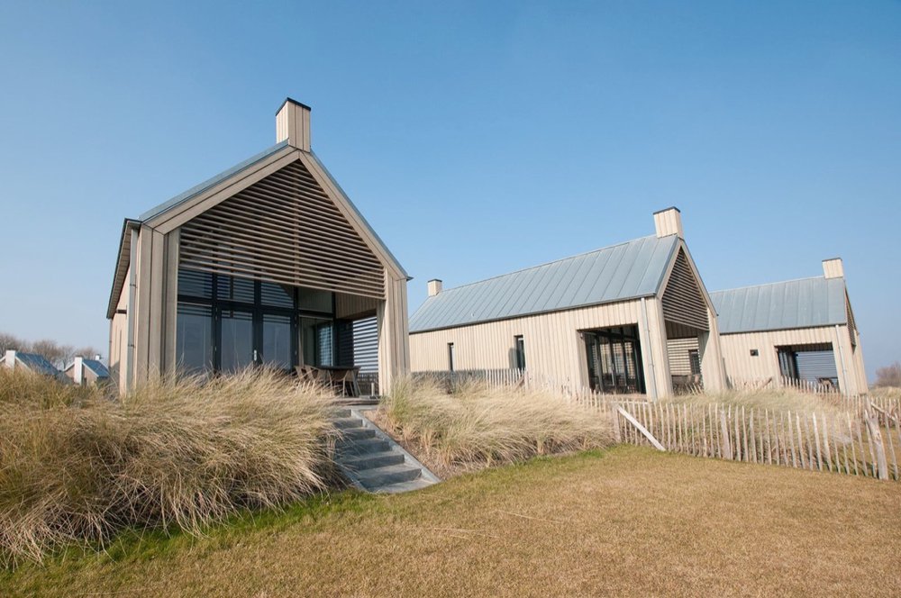 Vakantiehuizen op een park in Zeeland, met helmgras voor de deur