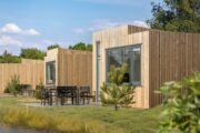 Een rijtje met houten lodges op een vakantiepark