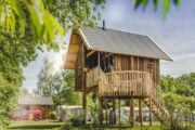 Houten boomhut in een groene omgeving
