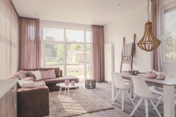 Lichte woonkamer met een eettafel, bank en grote ramen