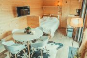 Zithoek in een tiny house met op de achtergond een tweepersoonsbed