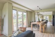 Woonkamer met grote ramen in de watervilla