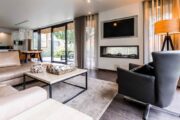 Woonkamer met sfeerhaard en openslaande deuren naar de tuin