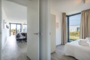 Zicht op de slaapkamer en woonkamer vanuit de hal van de Z'AND villa