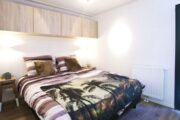 Tweepersoons bed in de slaapkamer van het tiny house
