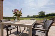 Tuin met eettafel en uitzicht op een grasveld