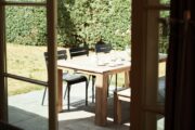 Kijkje vanuit het huisje op de eettafel op het terras