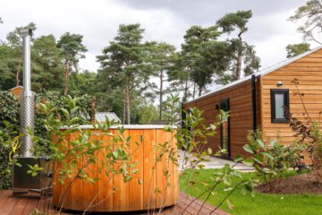Houten huisje met hot tub in de tuin voor een weekendje weg