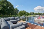 Terras met loungeset op het dek van de havenlodge van Marina Parcs
